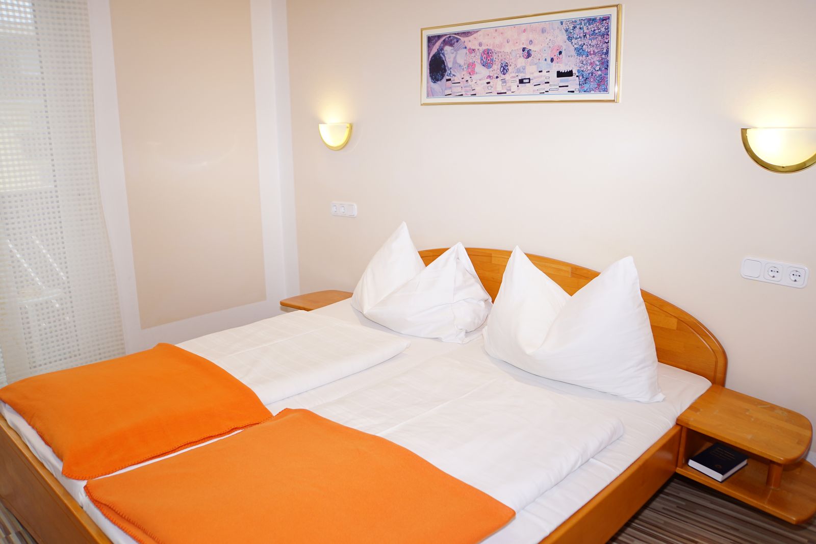 Doppelzimmer mit Balkon: Doppelbett mit Nachtkästchen und Wandleuchten